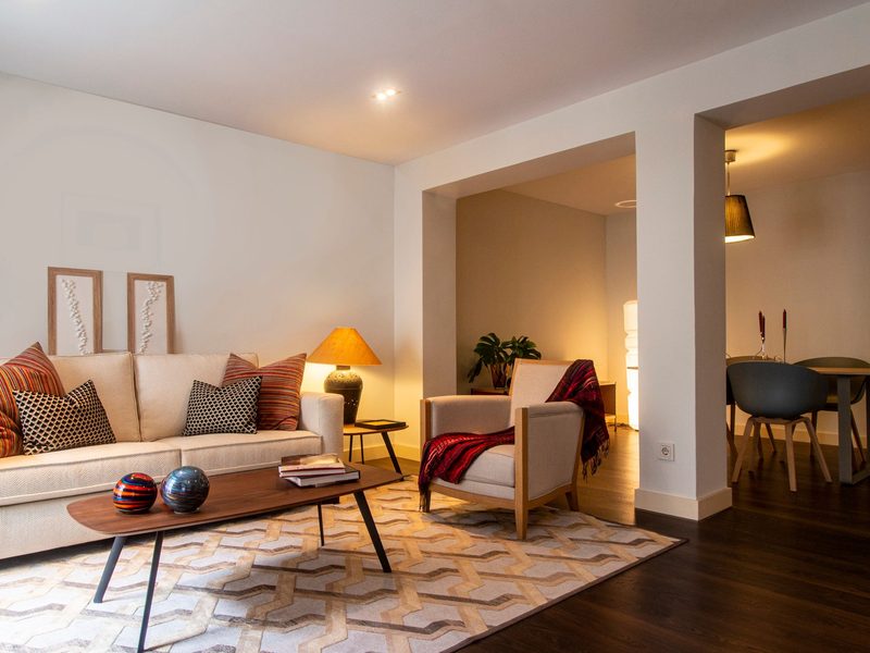 A cosy living room with soft seating and warm lamp light
